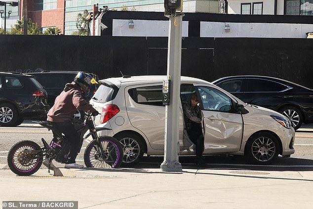 O fotógrafo iniciante estava dirigindo seu veículo de duas rodas roxo e preto quando bateu em um carro branco pouco antes do meio-dia. O amassado pode ser visto na porta