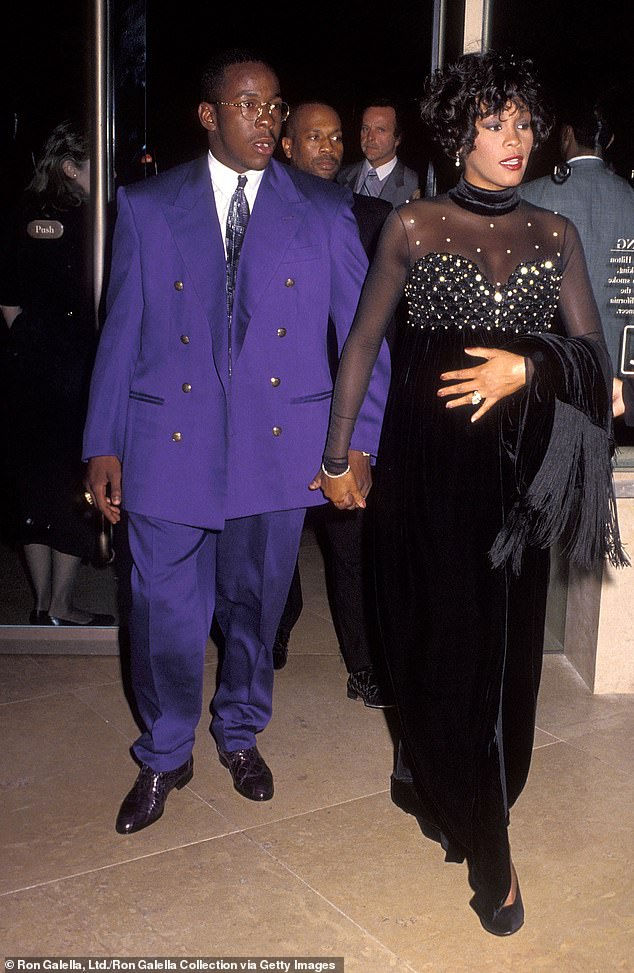 O sempre presente Roberts (Antecedentes) que guarda Whitney Houston em um evento de benefício em 1992
