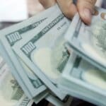 Dólar fecha abaixo de R$ 5, e bolsa cai com cautela global