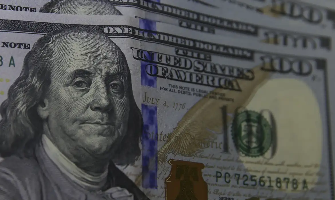 Cédulas de dólar e real ilustrando a cotação do câmbio